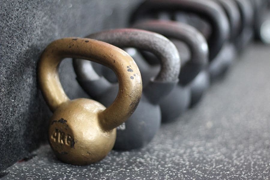 Fileira de kettlebells no piso de borracha de uma academia